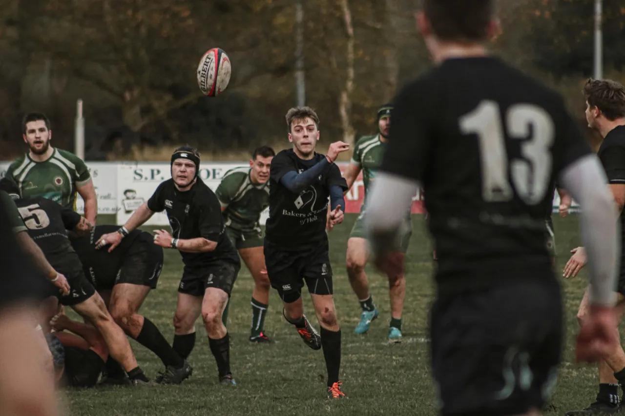 Players contesting a pass during a club rugby match