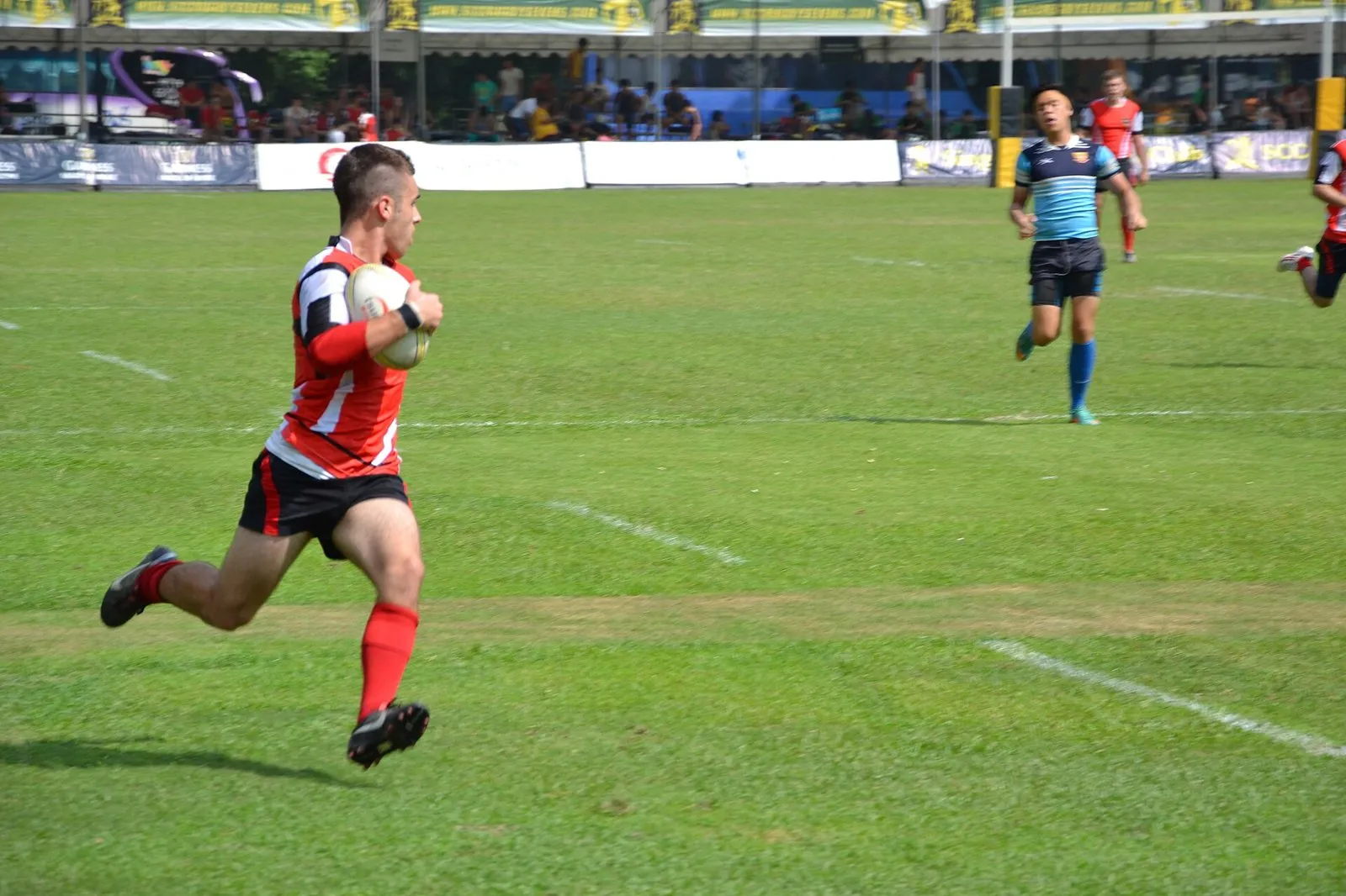 A schoolboy carries the ball forward during a rugby match