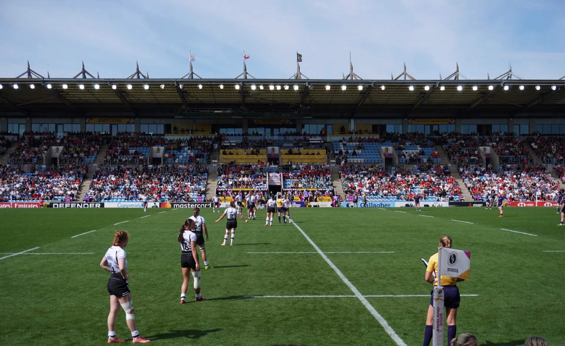 A women's international rugby match in progress in front of a full grandstand at Sandy Park