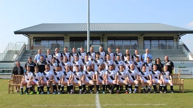 The Burton RFC squad in their black-and-white hoops outside the clubhouse at Battlestead Croft