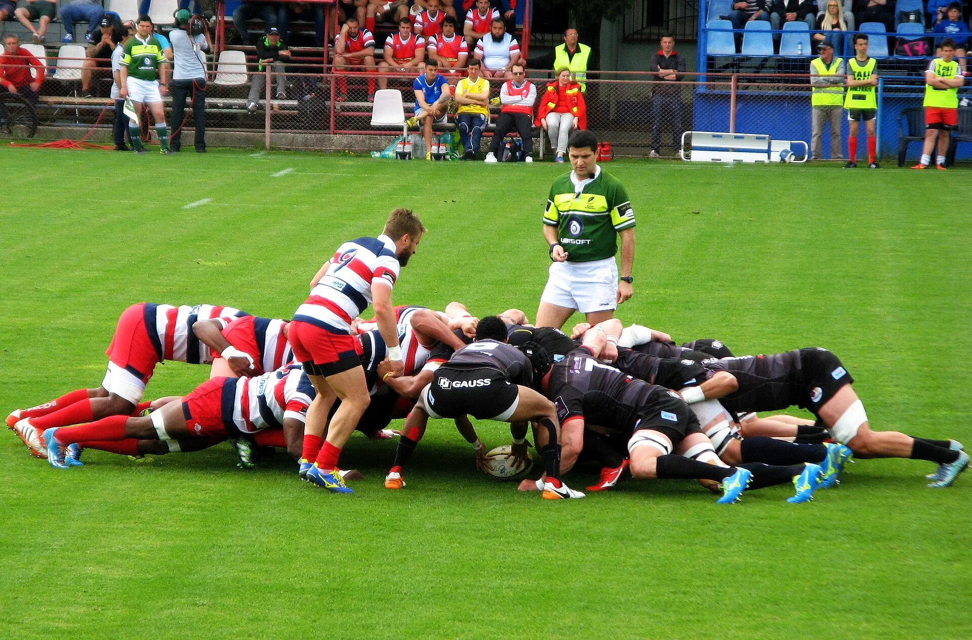 Two packs bind in a scrum as the scrum-half feeds the ball