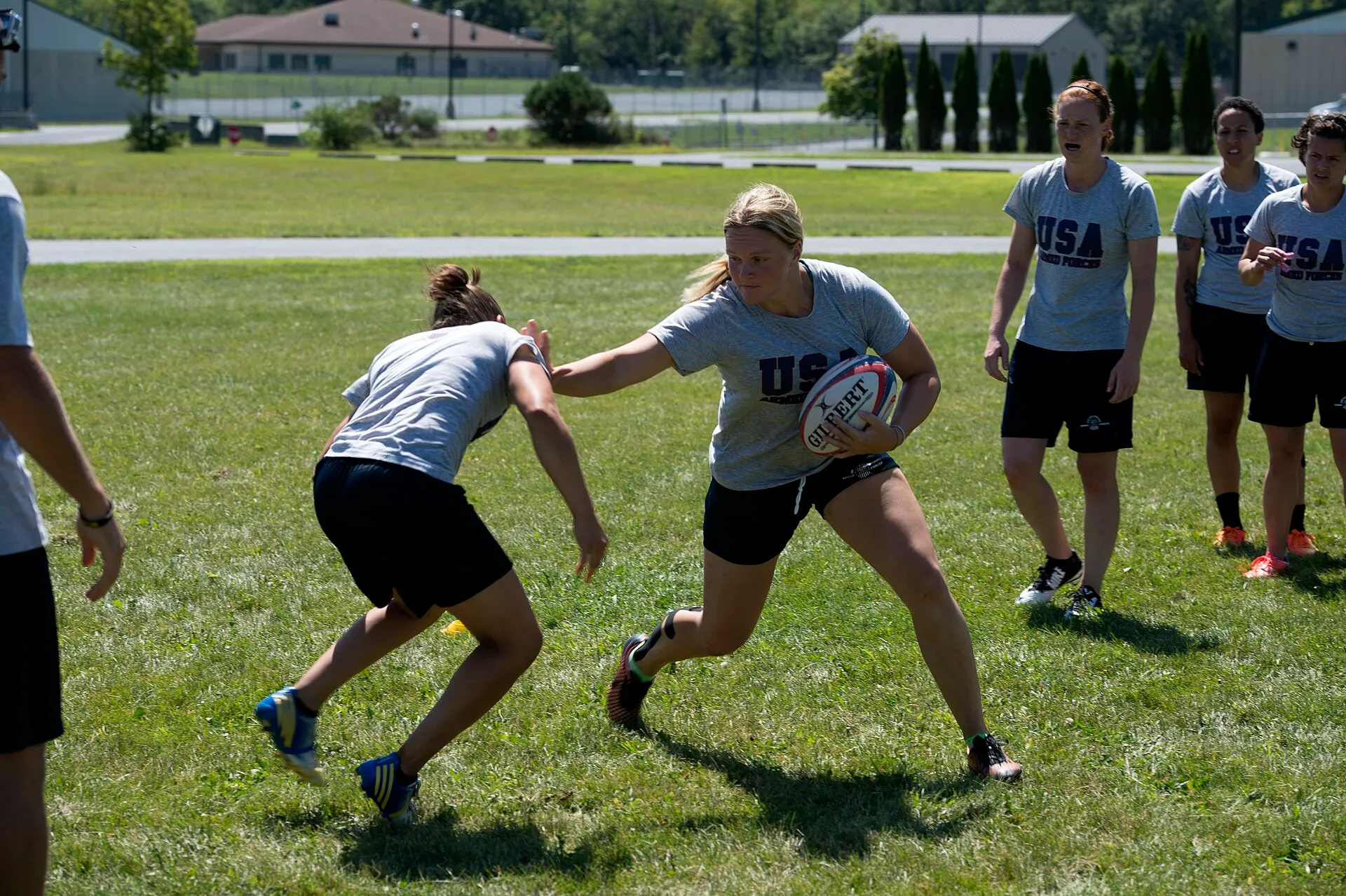 A ball carrier fends off a defender during a rugby training session