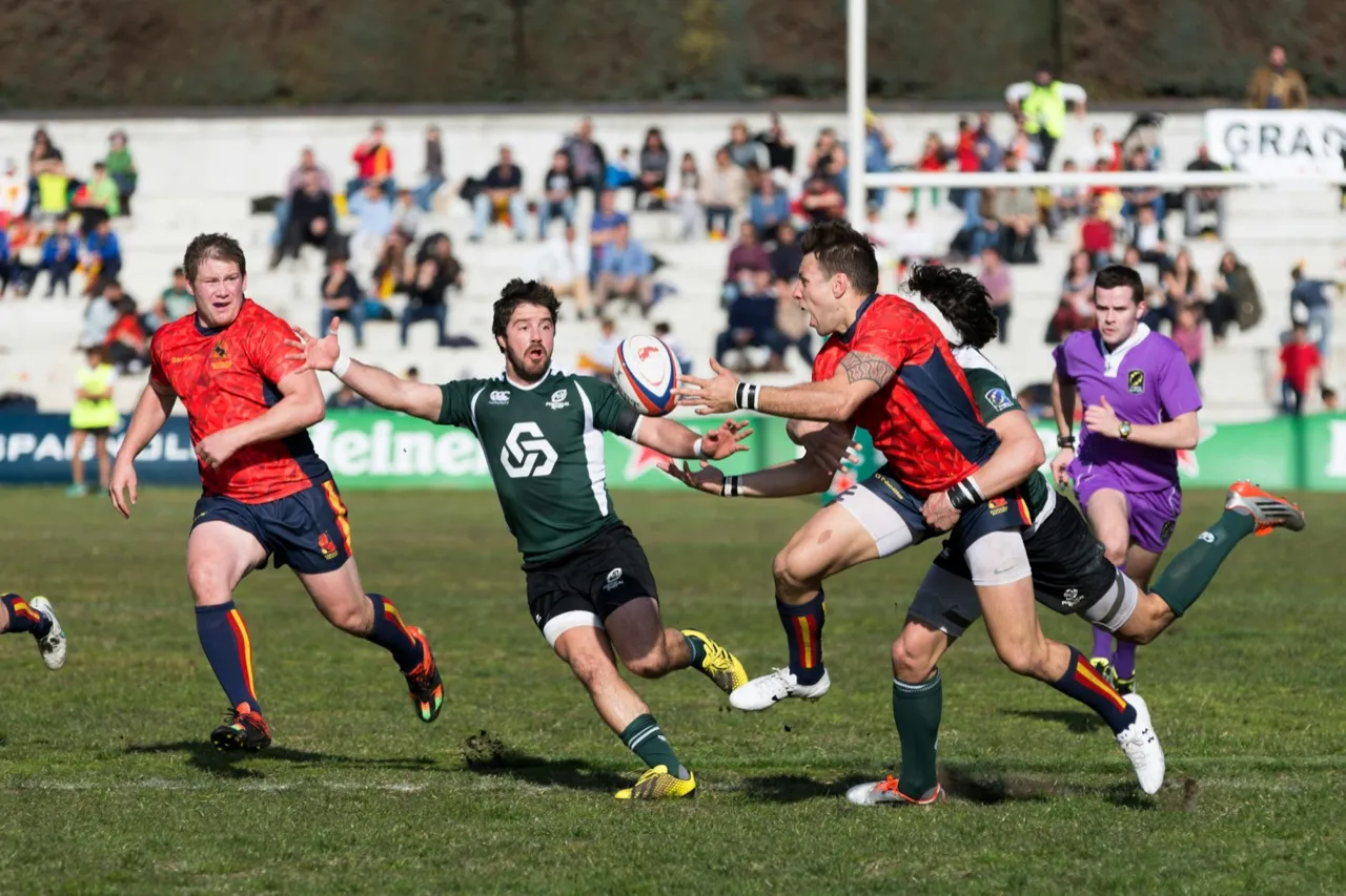 Players in red and green competing for the ball during a rugby match