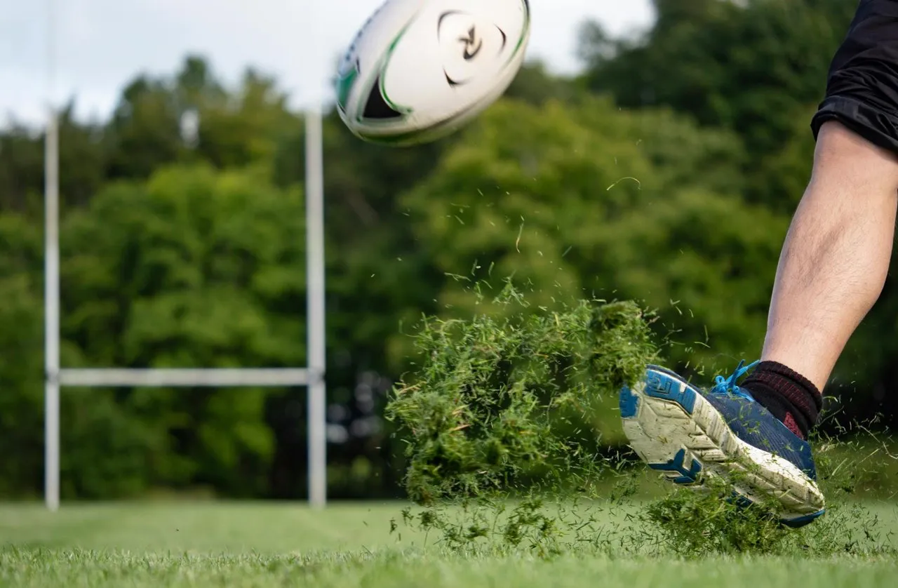 A rugby player kicking the ball during a match