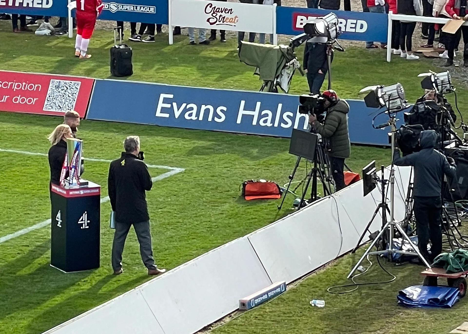 Broadcast cameras and monitors set up on the touchline at a rugby ground