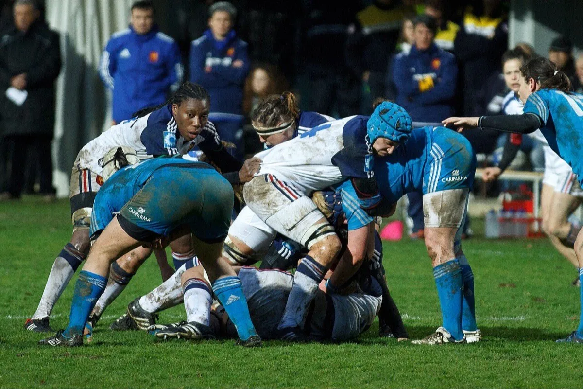 Players bind over the ball at a ruck during a rugby match