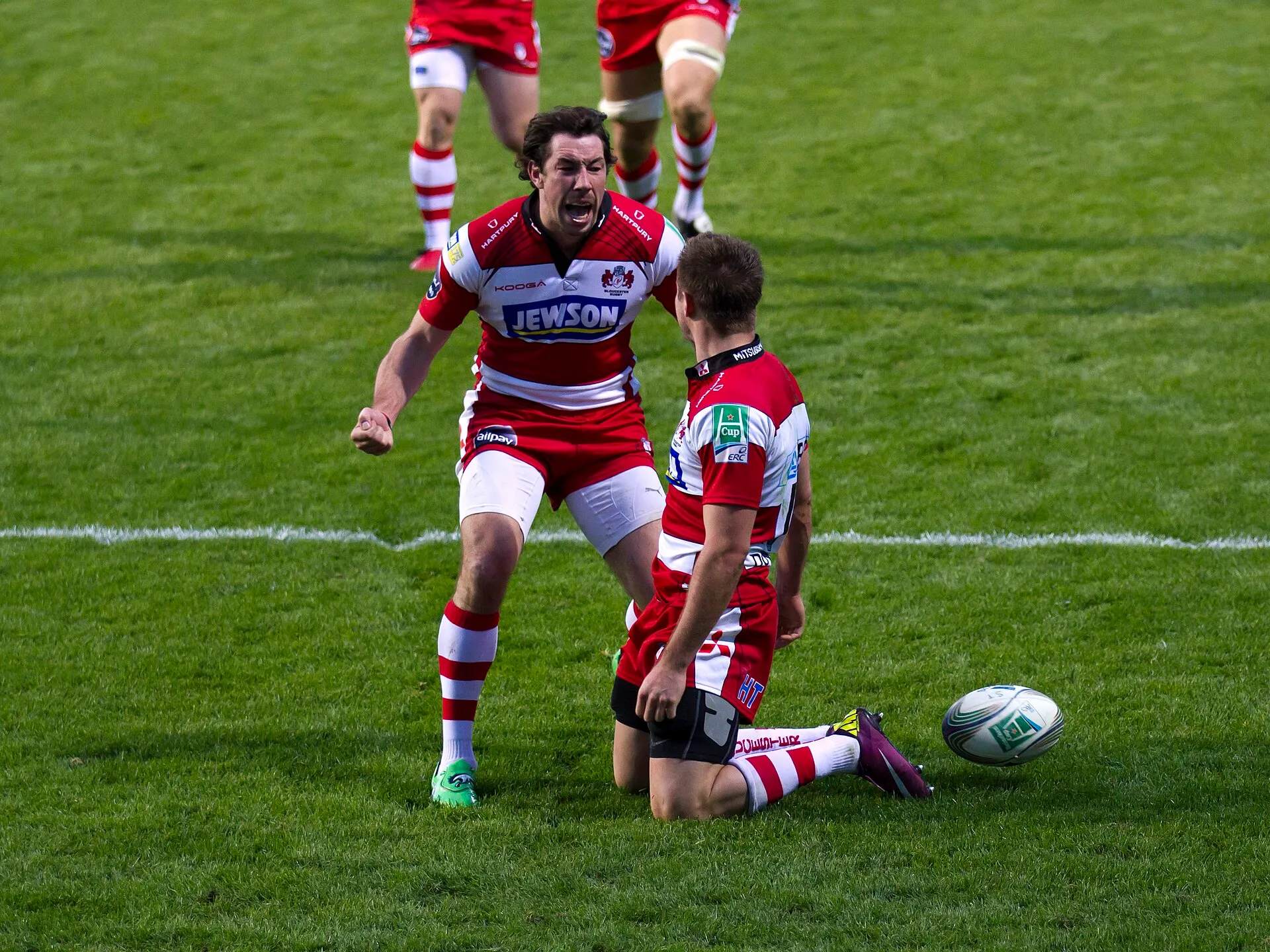A rugby team celebrates together after scoring
