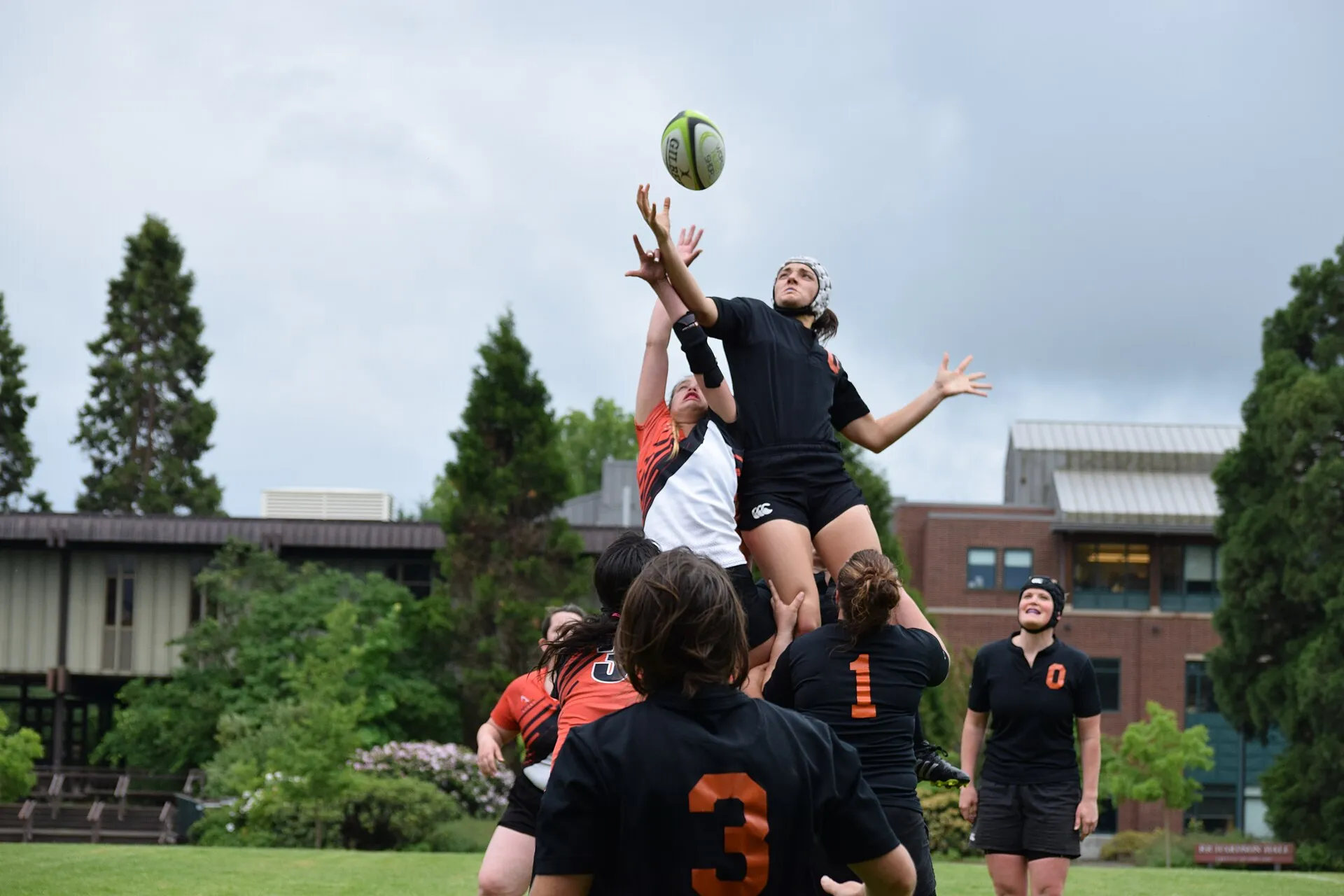 Amateur players leap for the ball at a women's rugby lineout