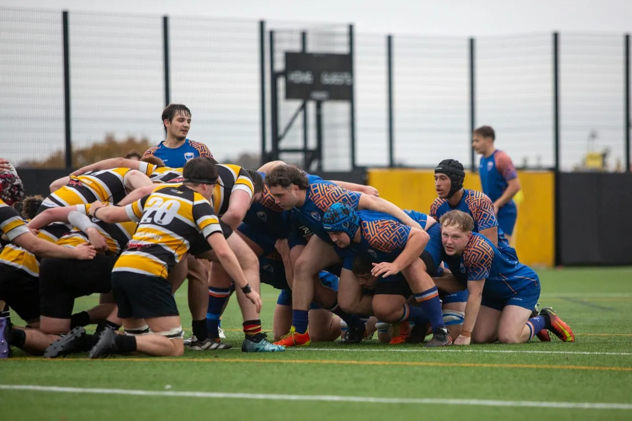 Two rugby packs engaged in a scrum during a match
