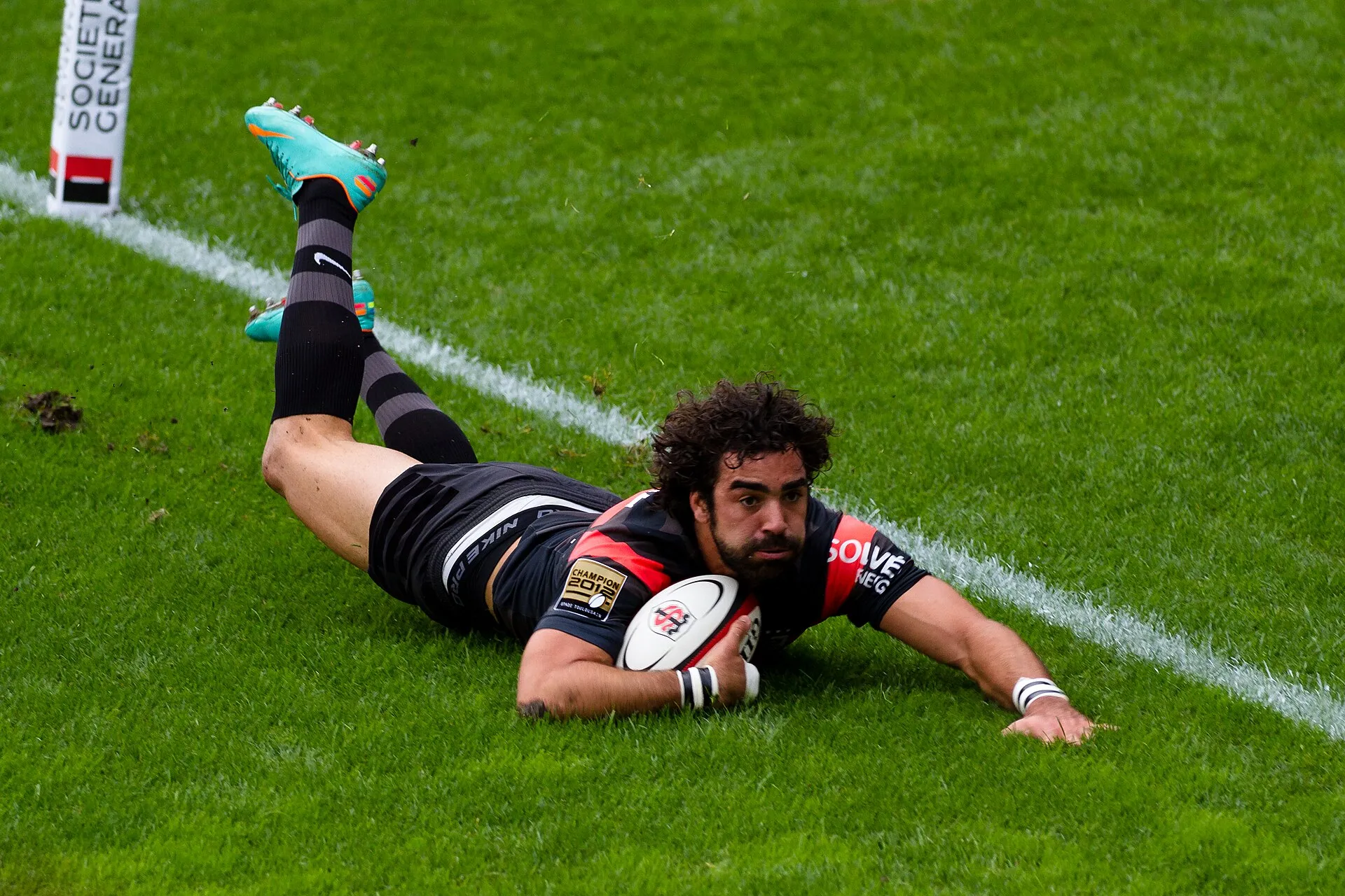 A rugby player touches the ball down for a try