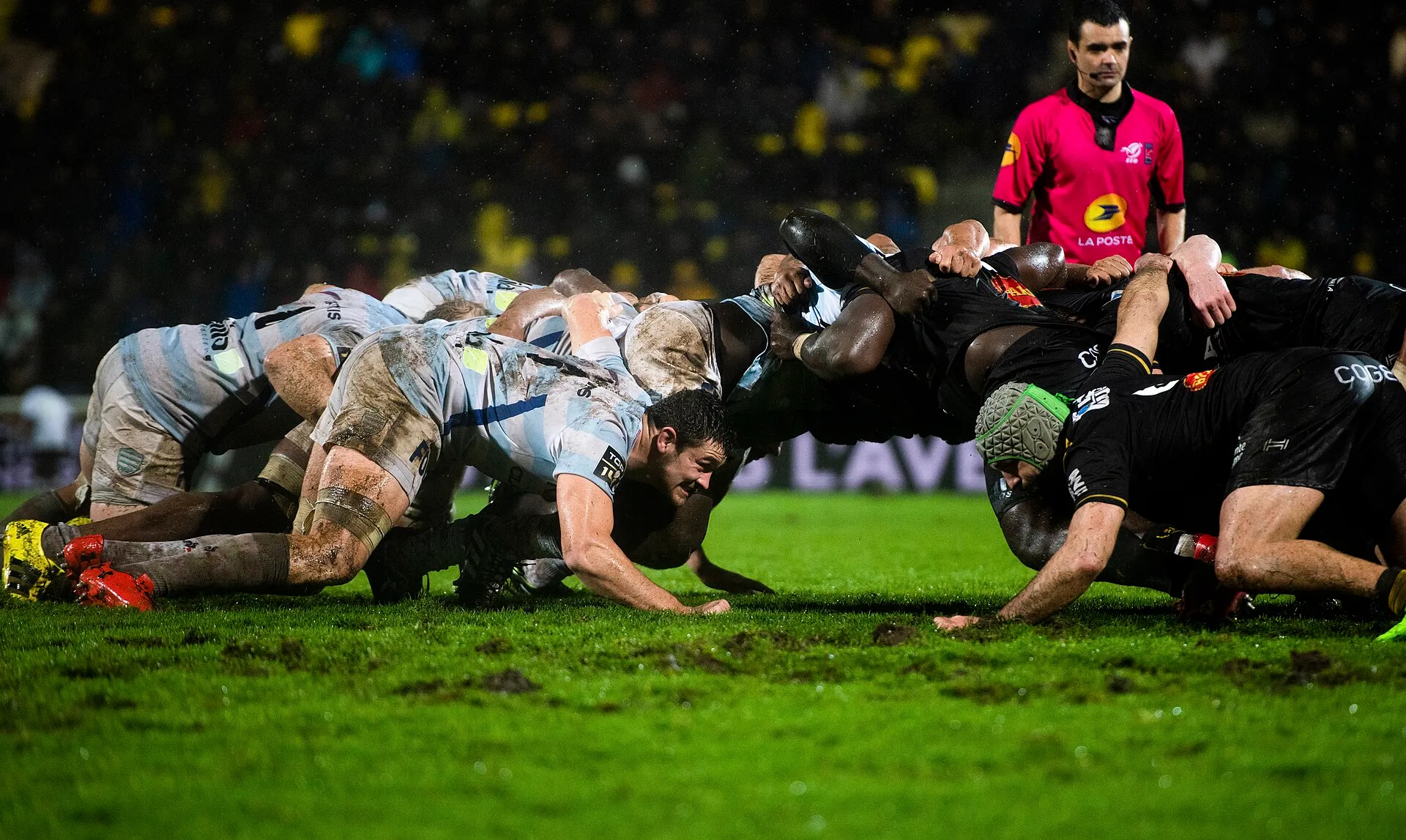Two front rows engage at a scrum during a rugby match