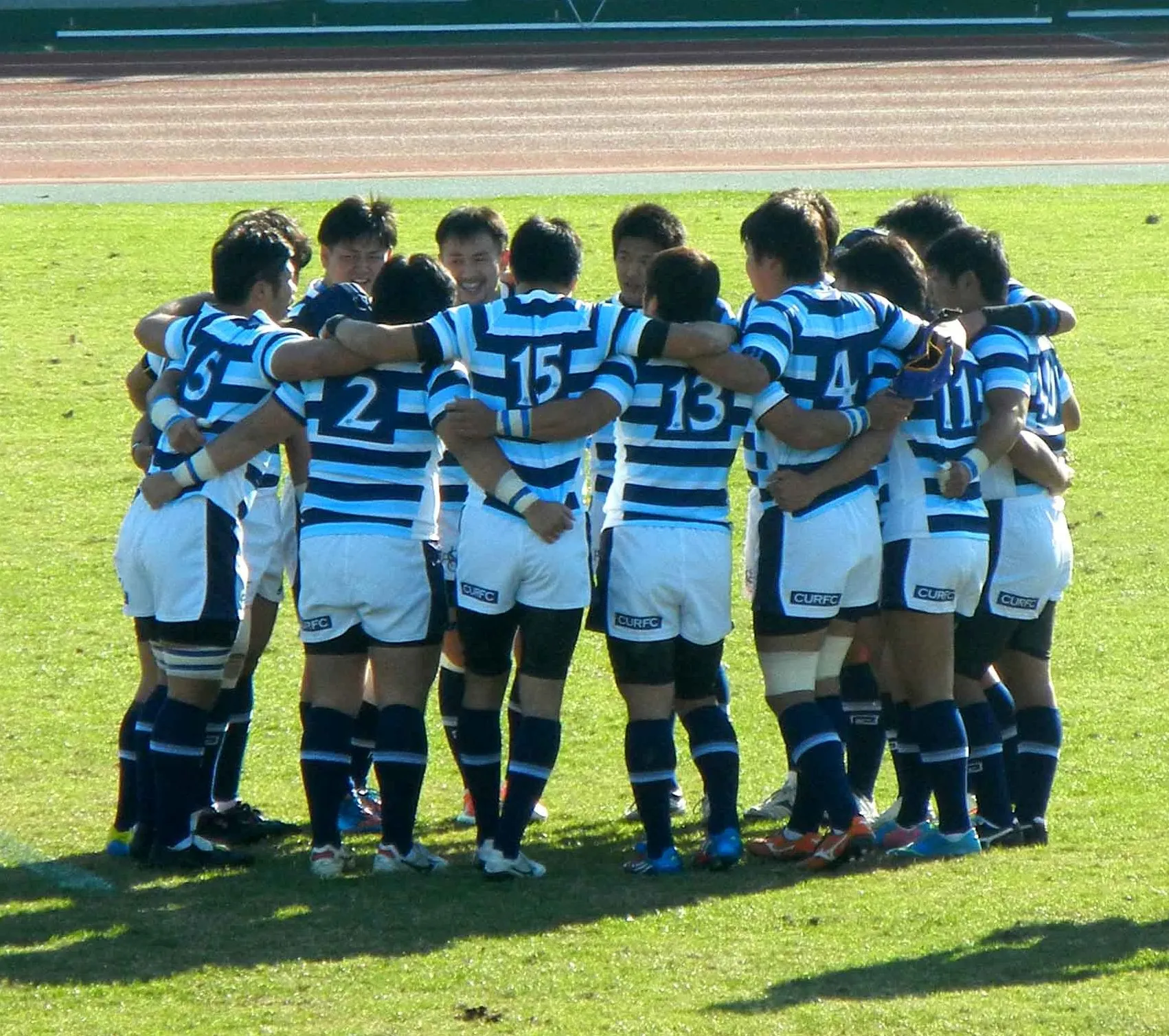 Rugby players huddle together during a break in play