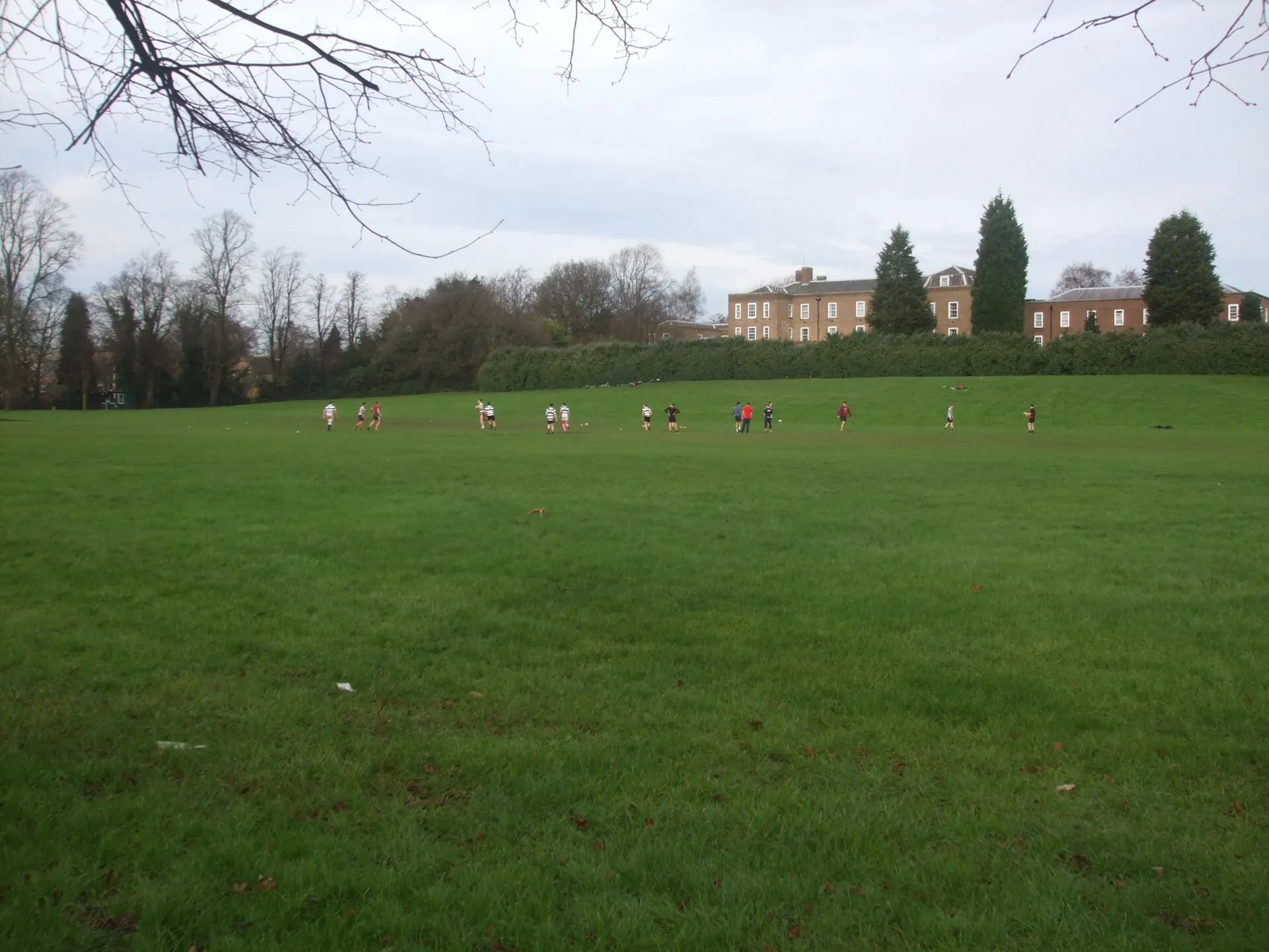 Players training on a park rugby pitch on a bare winter afternoon