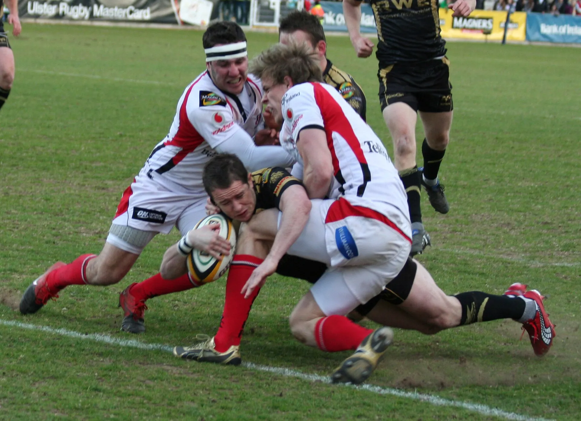 A player reaching out to ground the ball over the try line in a tackle