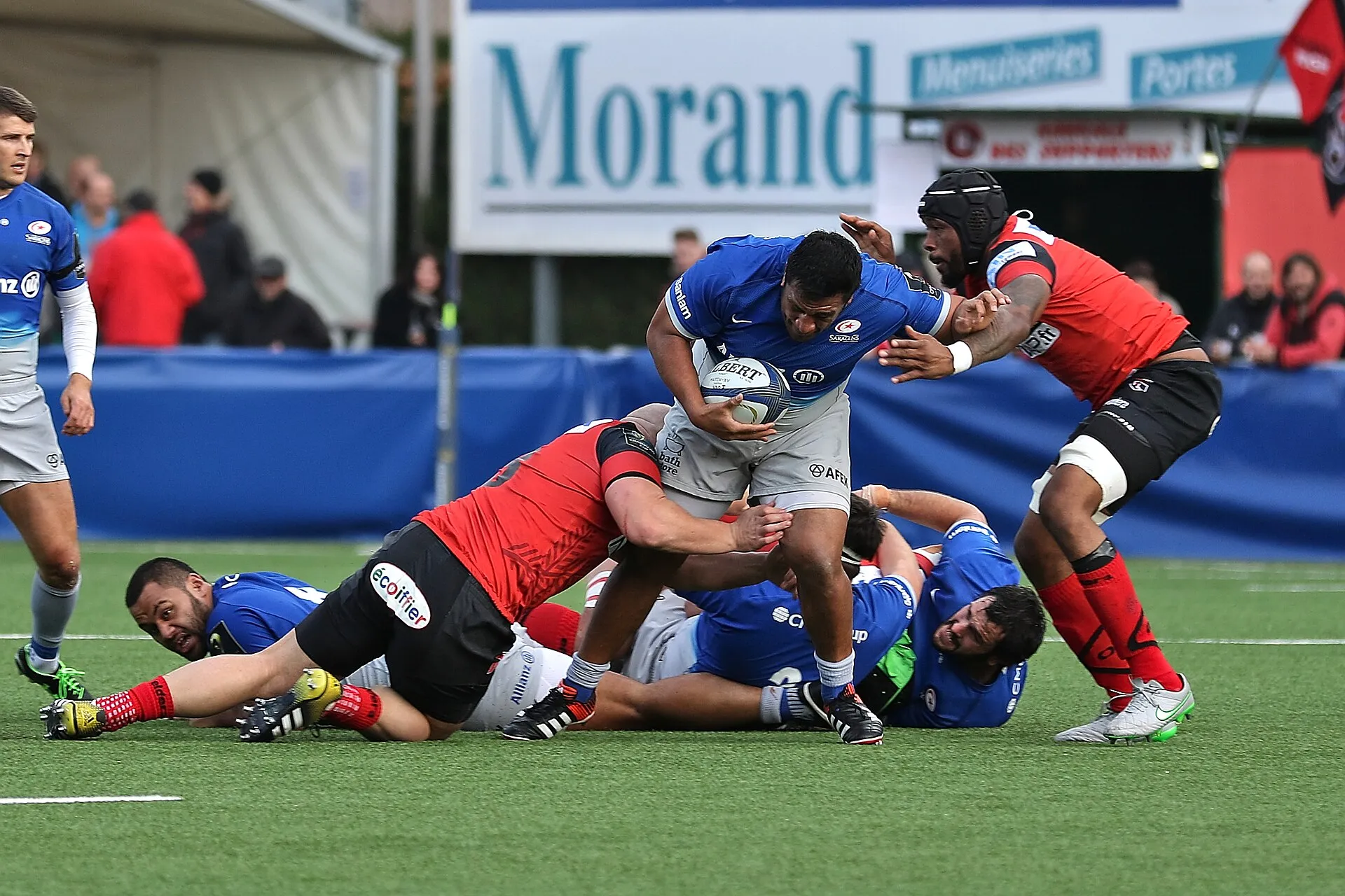 A defender wraps up a ball carrier in a rugby tackle